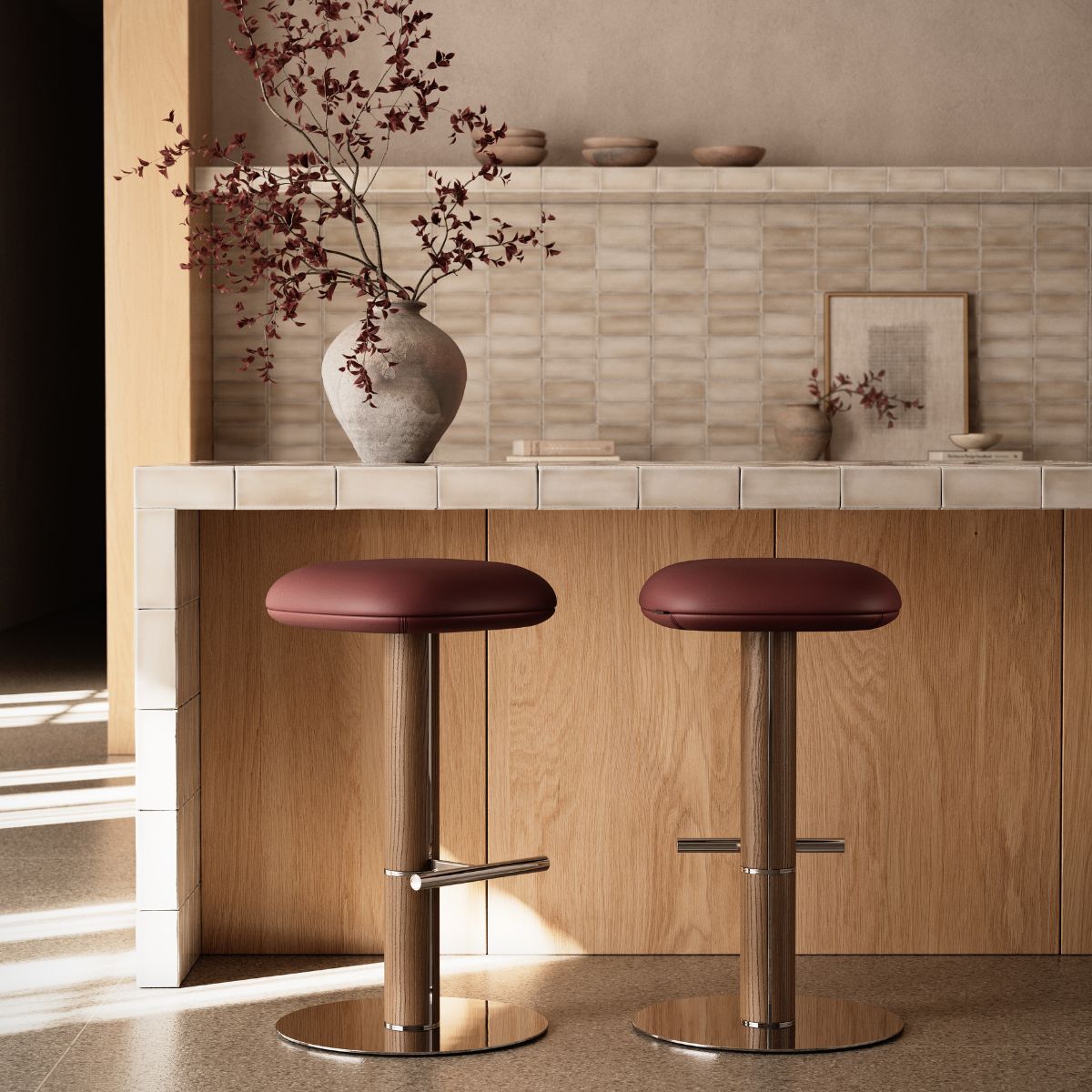 Hiro bar chair by Domkapa Two wooden stools positioned in front of a modern kitchen counter, ready for seating.