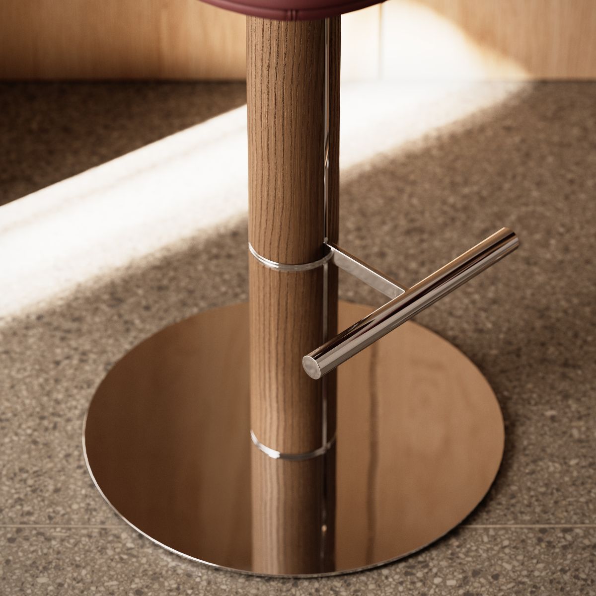 Hiro bar chair by Domkapa Detailed view of a wooden stool with a sleek metal base, showcasing the blend of materials and textures.