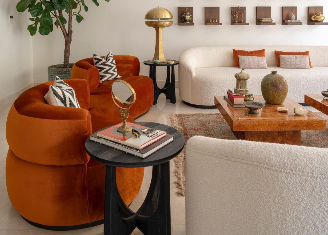 A Interiors Project A Interiors design project in Saudi Arabia. The project has neutral colours contrasted with orange tones and gold. The armchairs are in orange and the sofa is in bouclé white.