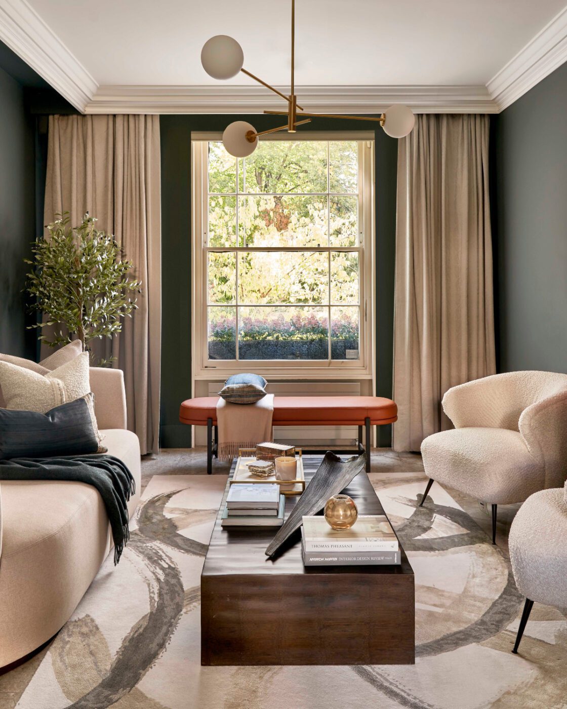A The Stylish Friend project with Colbert Bench A well-lit living room showcasing a large window, a red bench and a substantial rug that adds warmth to the space.