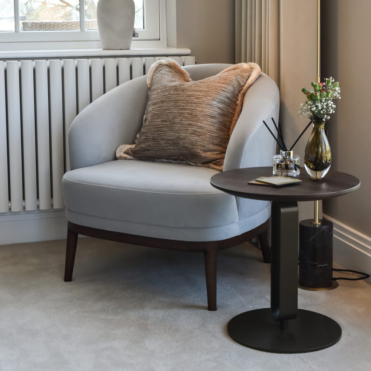 Ana Frantz Photography-Ruth Armchair corner A modern grey armchair and a lamp sit together in a room, adding a touch of elegance to the decor in a master bedroom design.