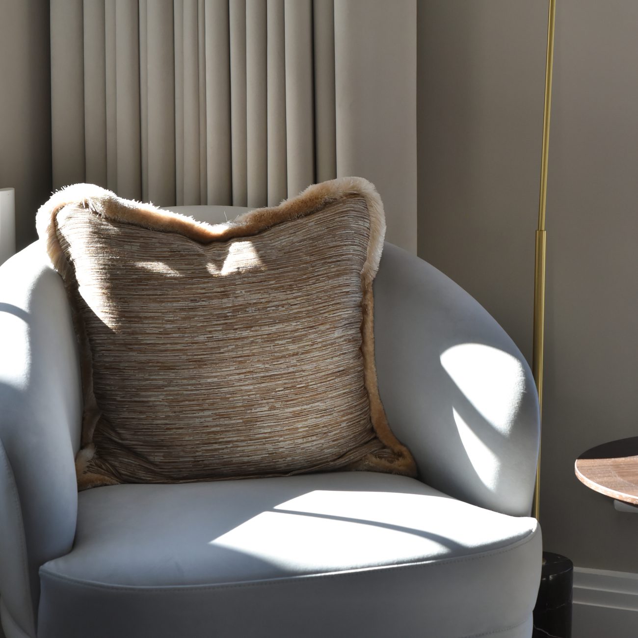 Ana Frantz Photography-Ruth Armchair details A comfortable armchair adorned with a pillow, next to a lamp, set in a stylish master bedroom design.