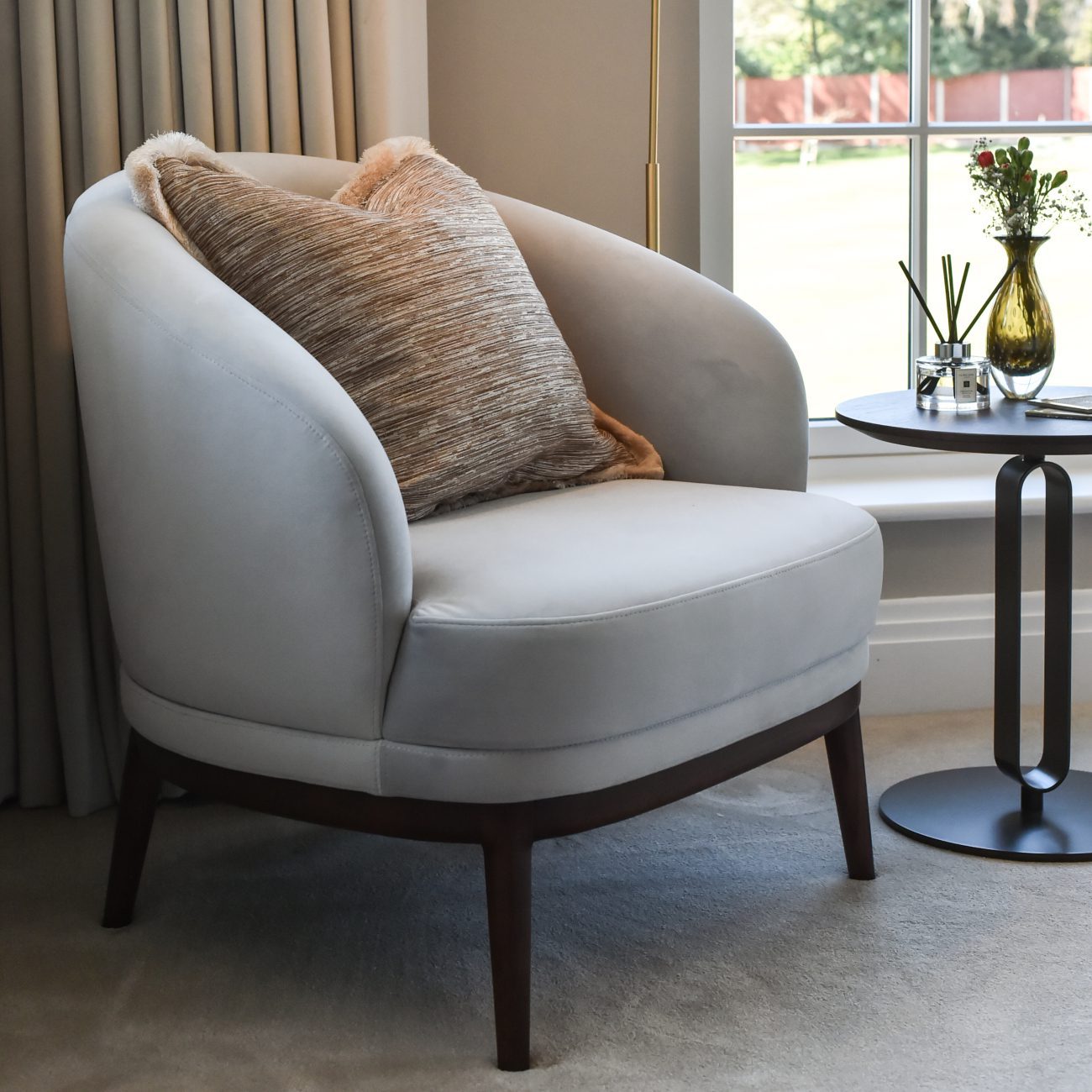 Ana Frantz Photography-Ruth Armchair A simple armchair and table set against a window, creating a serene spot for reading or enjoying the view in a master bedroom design.