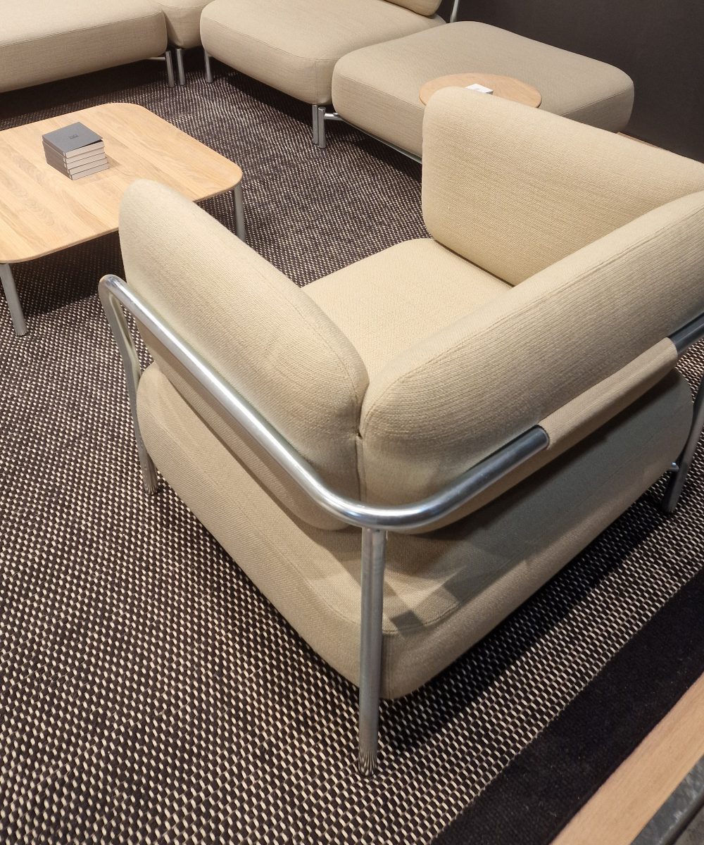 White armchair in organic forms and upholstered in white. With metal details. Captured at Salone del mobile 2025.
