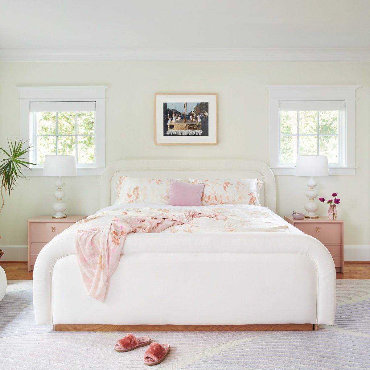 Bedroom at J.Fisher Interiors Project Bedroom in white colours. The bed, the carpet and the walls are white and the bedside tables are light pink.