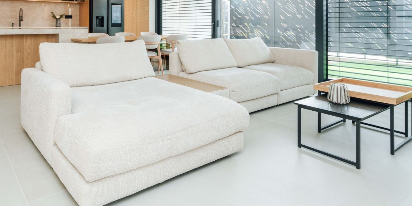 Modern living room featuring white furniture complemented by warm wooden accents. Project by Estilia Design.