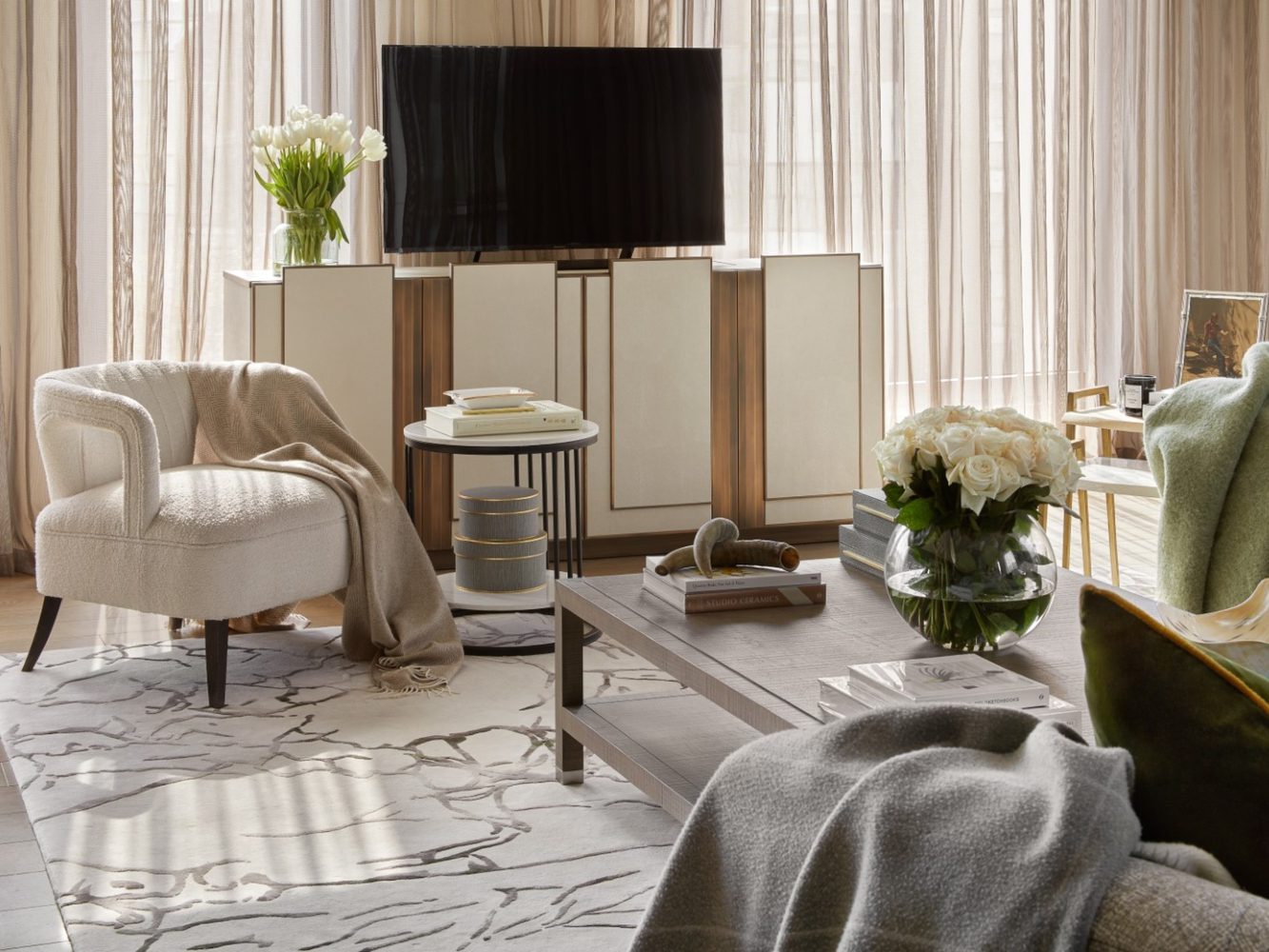 Celine Interior Design (1) Living room project by Celine Interior design. With neutral tones and a armchair with boucle fabric. With a tv cabinet in white and gold accents.