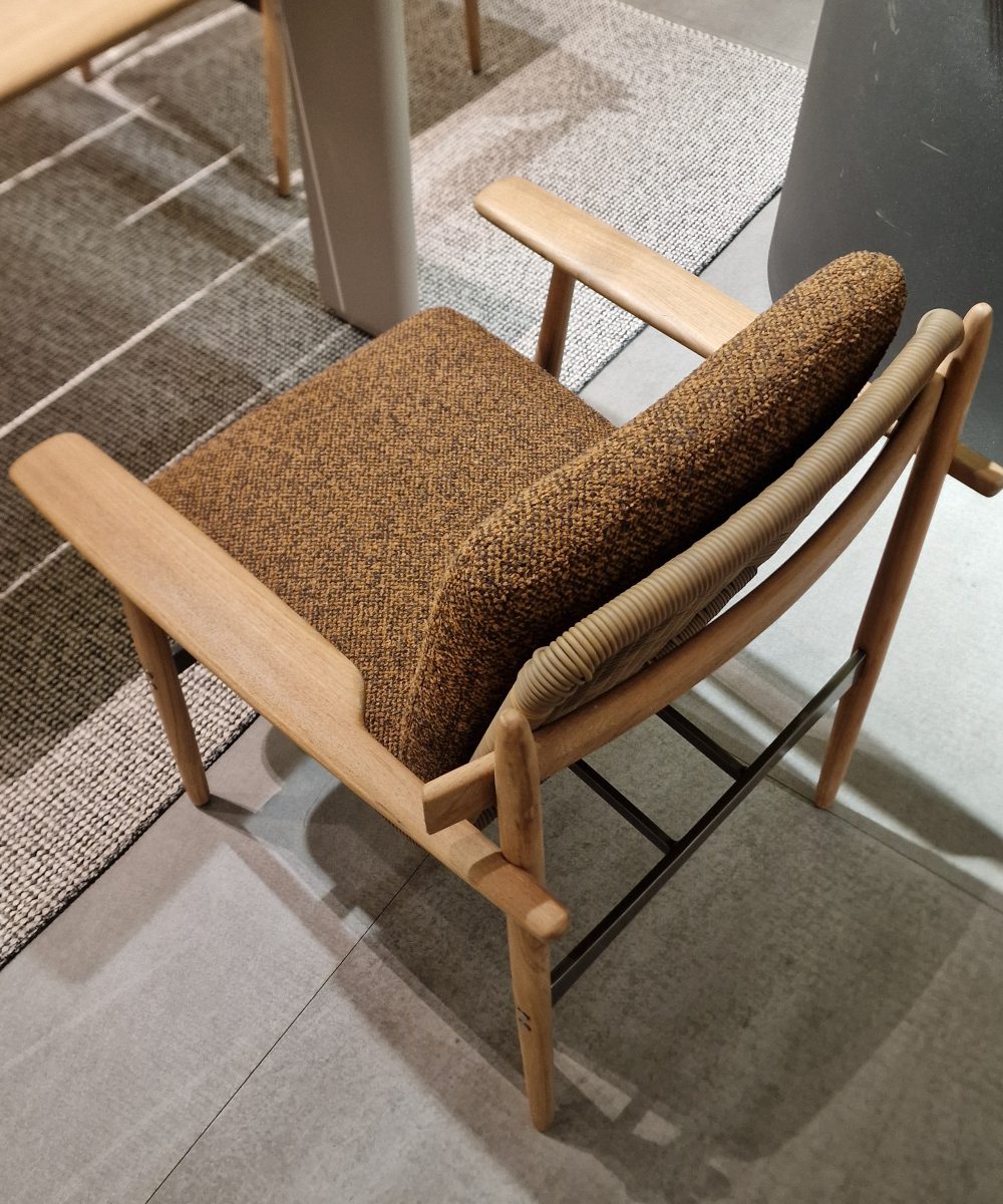 Dining chair in wood and the seating upholstered in terracotta fabric.