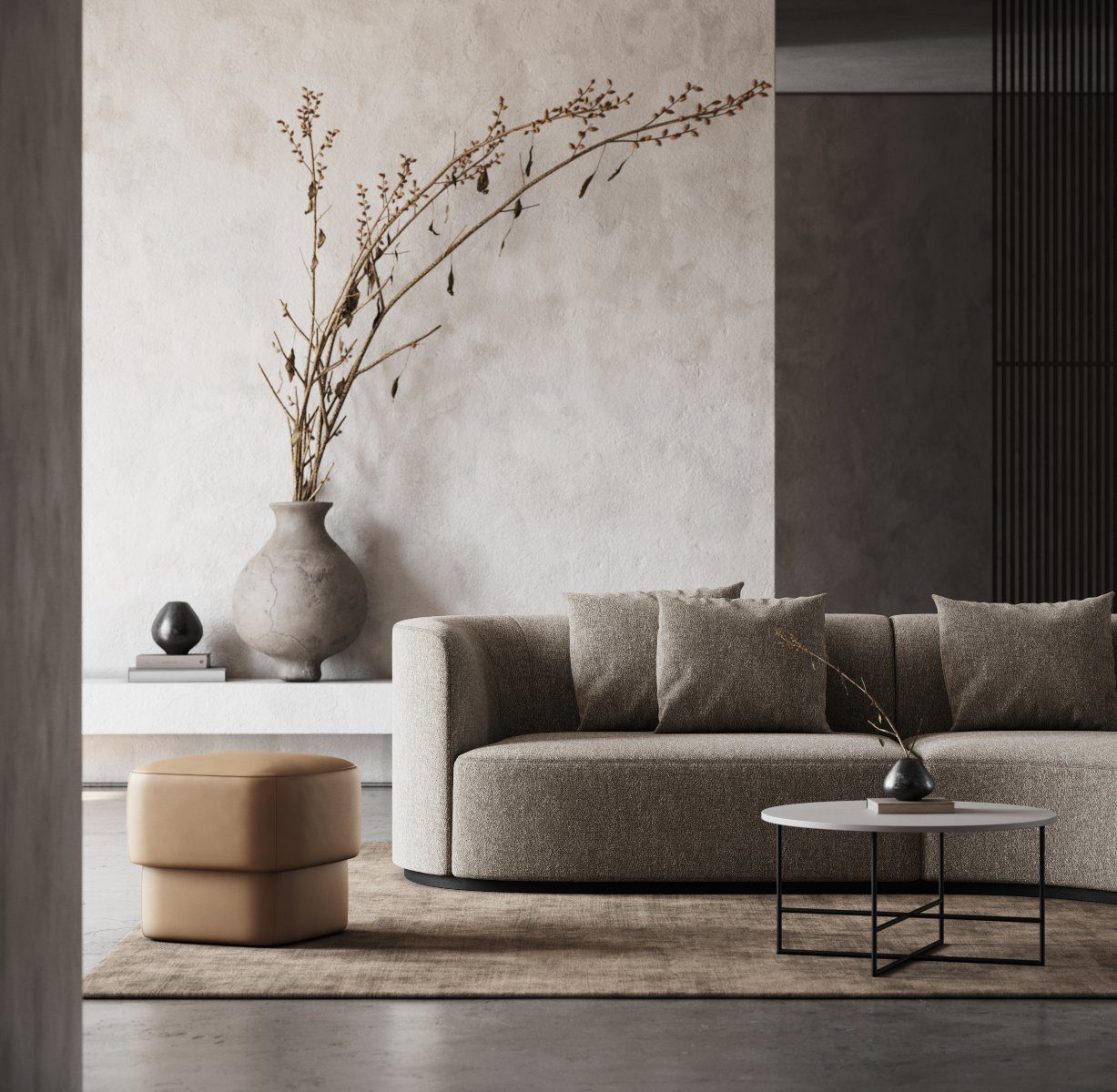 Chloe Sofa & Kate Pouf Living room with a comfortable sofa, a bege pouf and a round coffee table. The main colours are neutral and browns. It has a vase in the back of the room.
