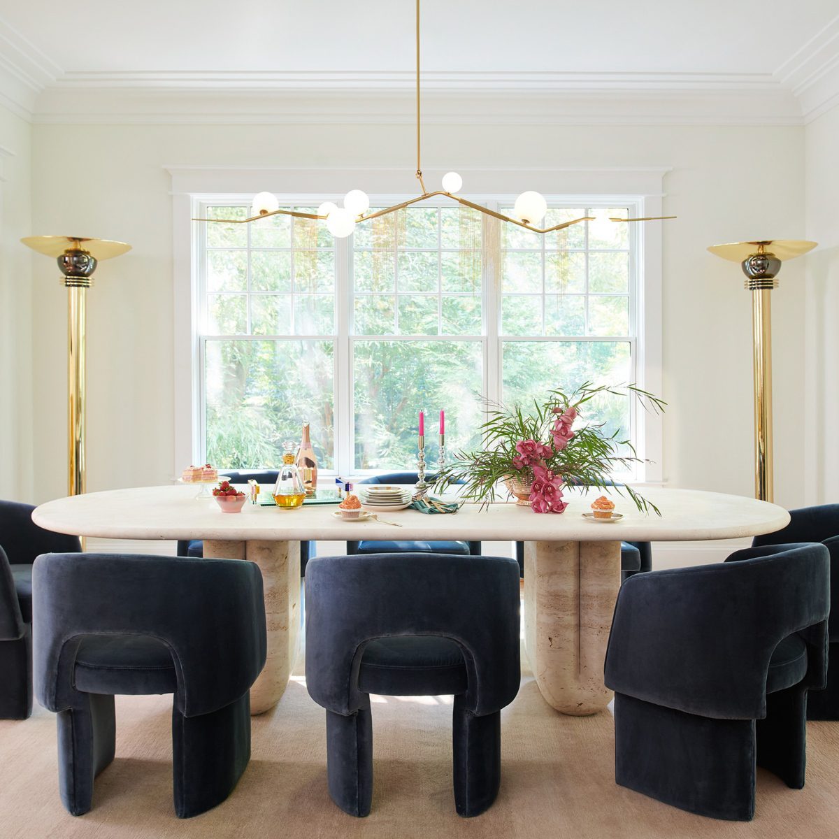 Dining Room at J.Fisher Interiors Project Dining room with navy blue dining chairs and white marble dining table. With gold accents at the lighting.