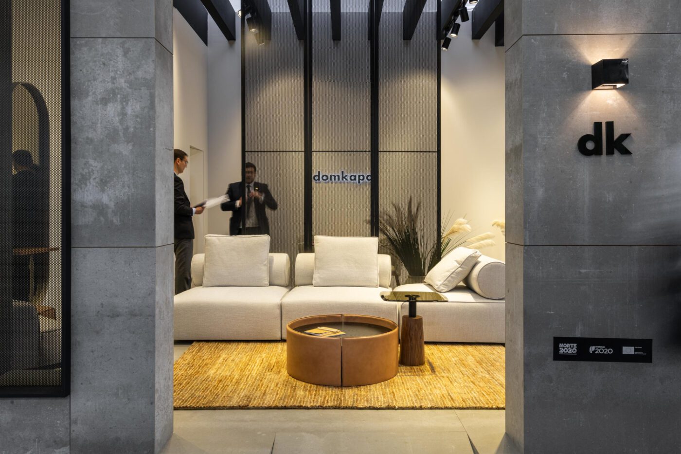Domkapa at decorex 2021 Modern interior with white furnishings and a coffee table, offering a fresh and organized work environment. Domkapa's stand at Decorex.