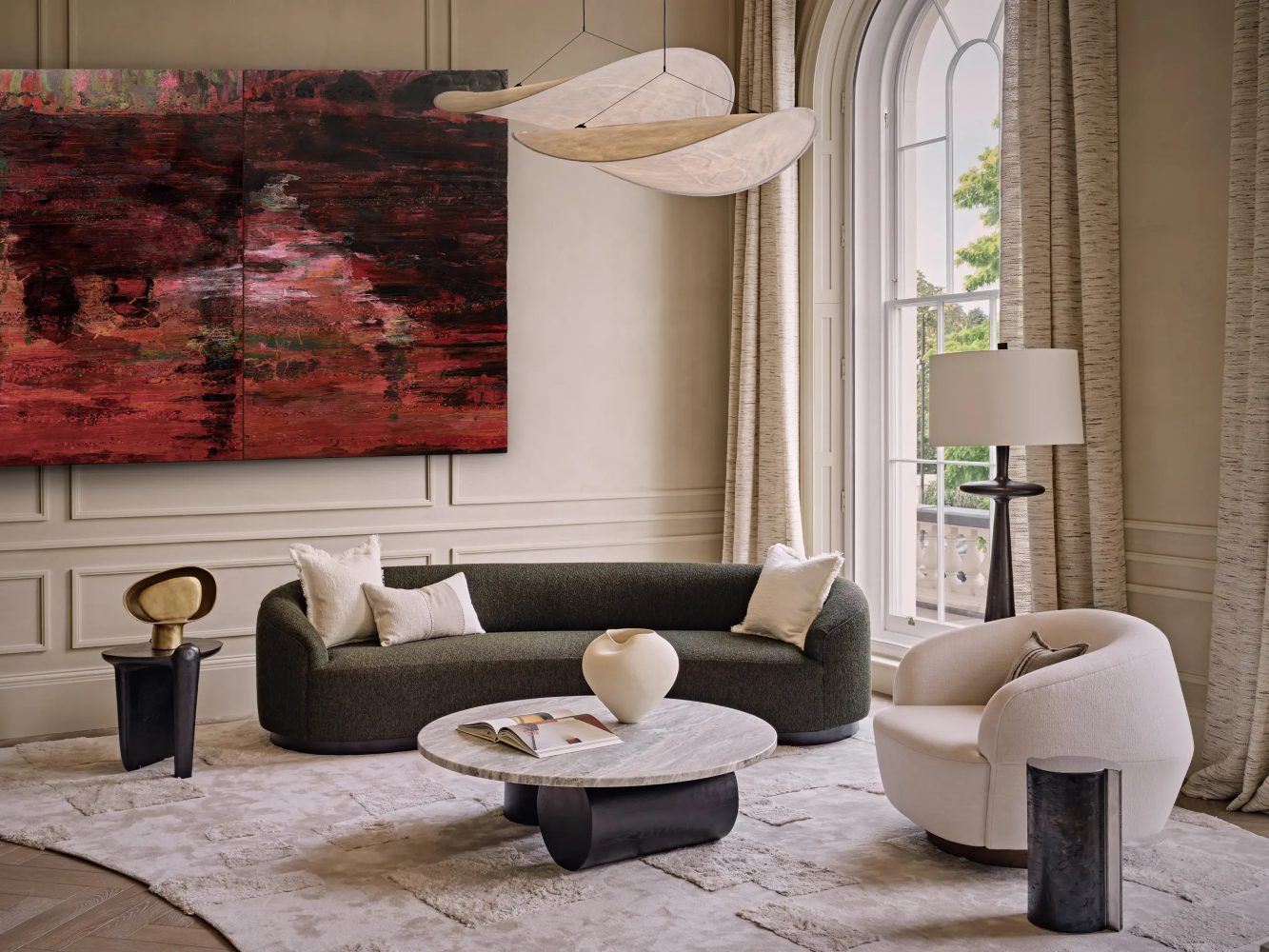 Elicyon Living room project by Elicyon with a dark sofa and a white armchair. At the centre has a coffee table with a black base and a top in marble. On the side of the sofa and the armchair it has two side tables in black and gold. On the wall it has a red artwork.