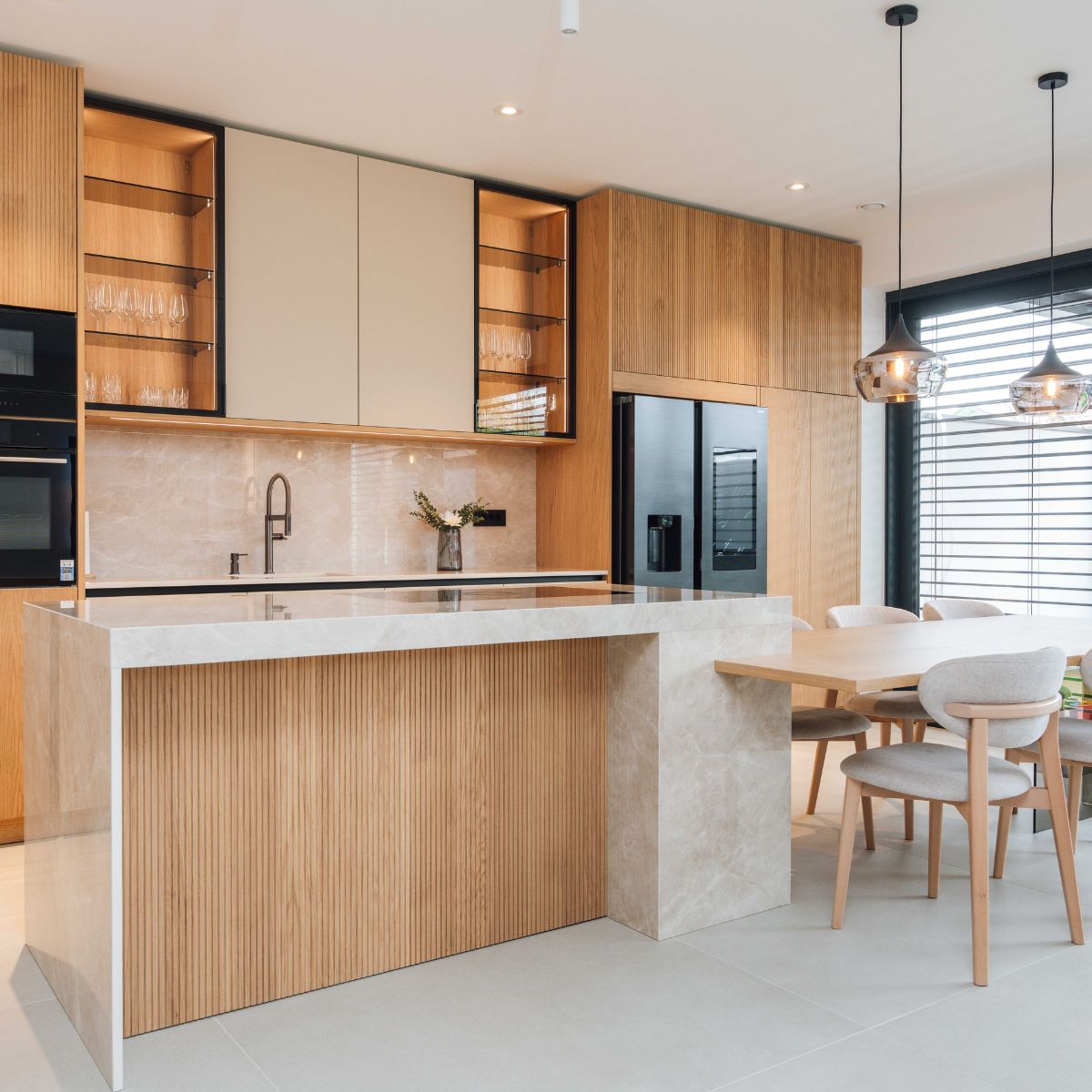 Contemporary kitchen with wooden cabinetry and a dining table, highlighting a blend of elegance and practicality.