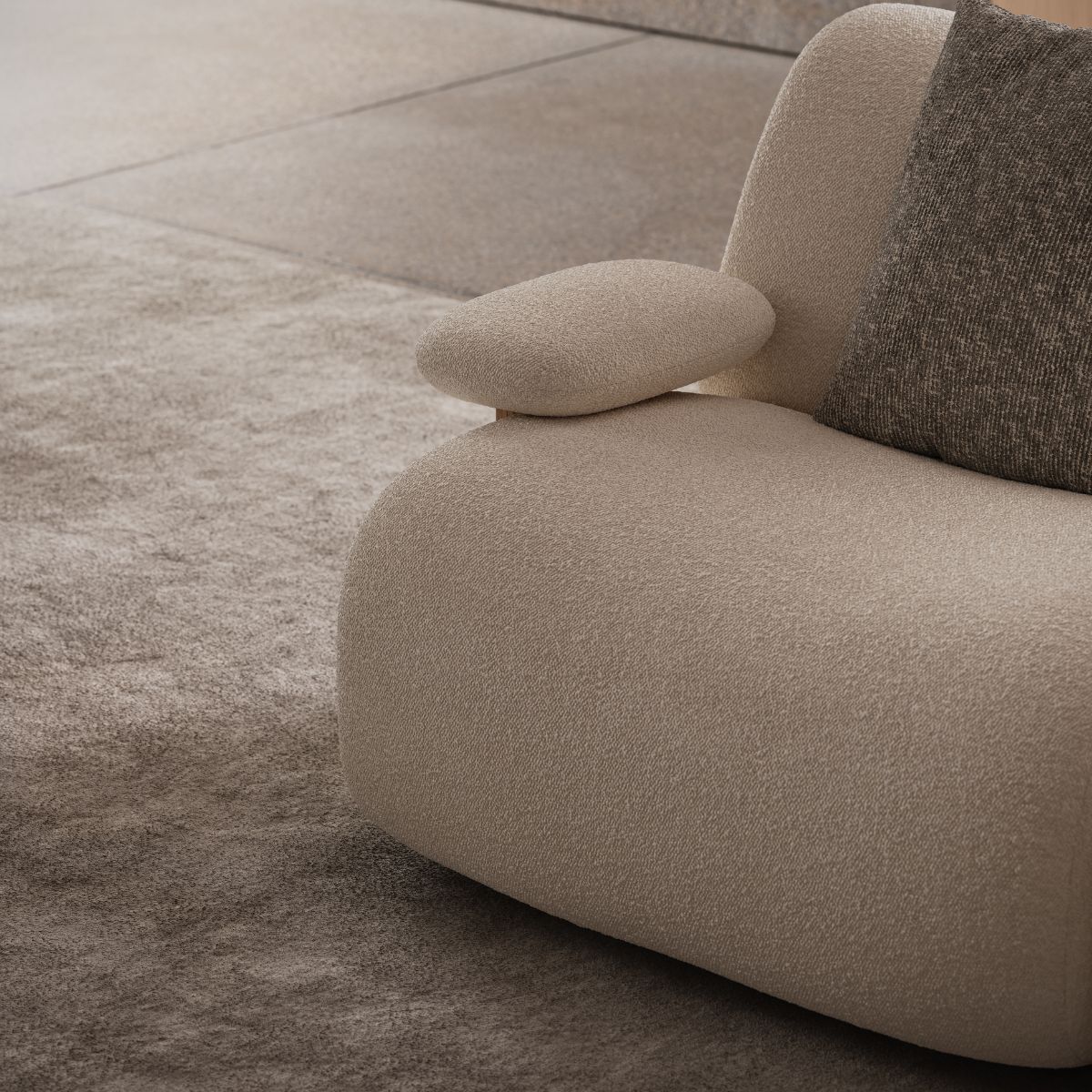 A beige sofa featuring a plush pillow, inviting relaxation in a minimalist setting.