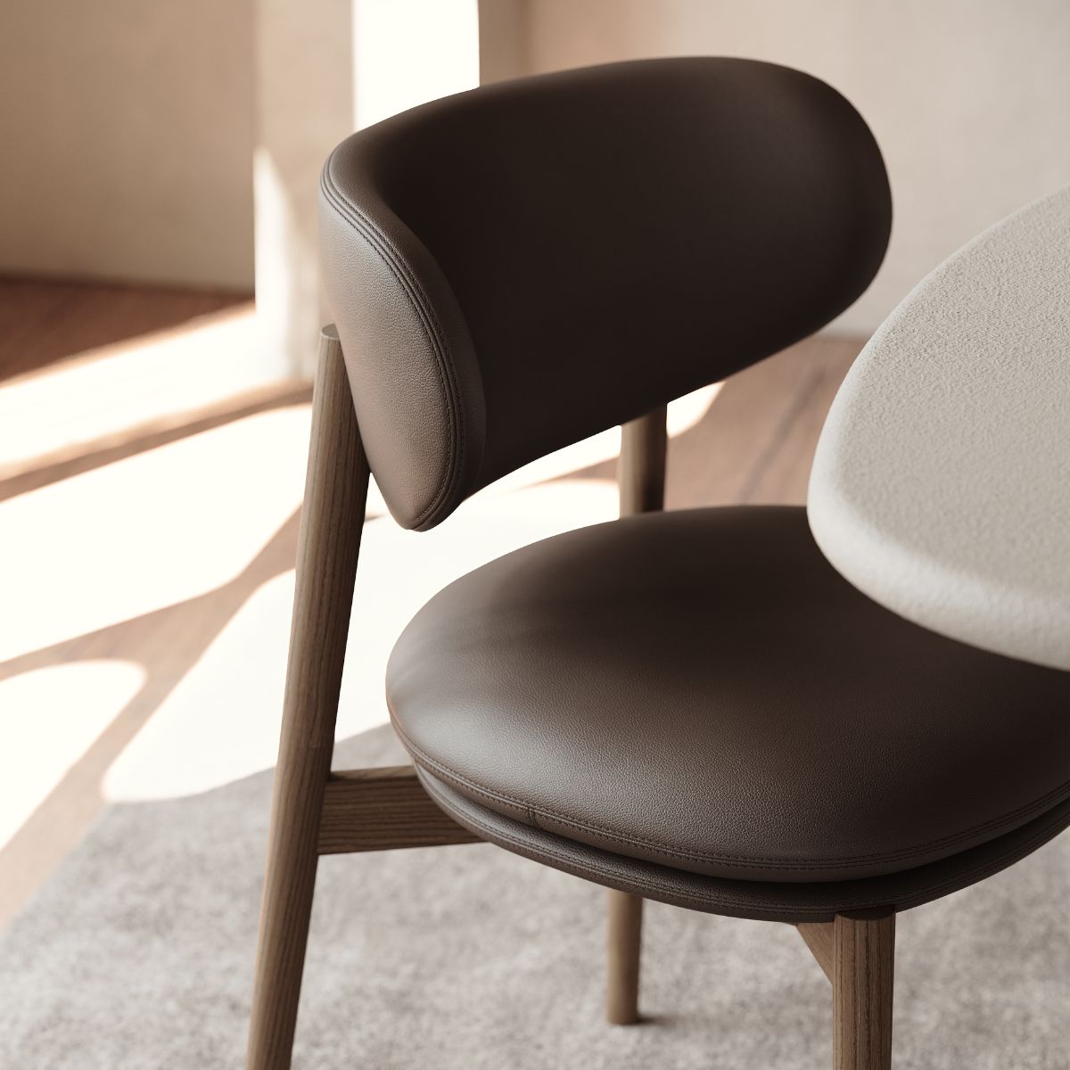 Harvey Dining Chair by Domkapa (1) Dining chair with a brown leather seat positioned next to a round table.