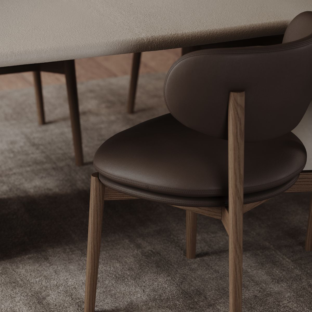 Harvey Dining Chair by Domkapa (3) A brown leather seat chair positioned next to a wooden table, showcasing a simple and elegant design.