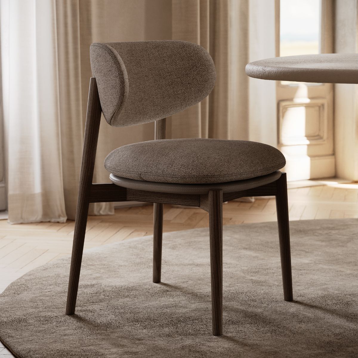 Harvey Dining Chair by Domkapa Harvey Dining Chair by Domkapa and round table placed in front of a window, enhancing the room's natural light and openness.