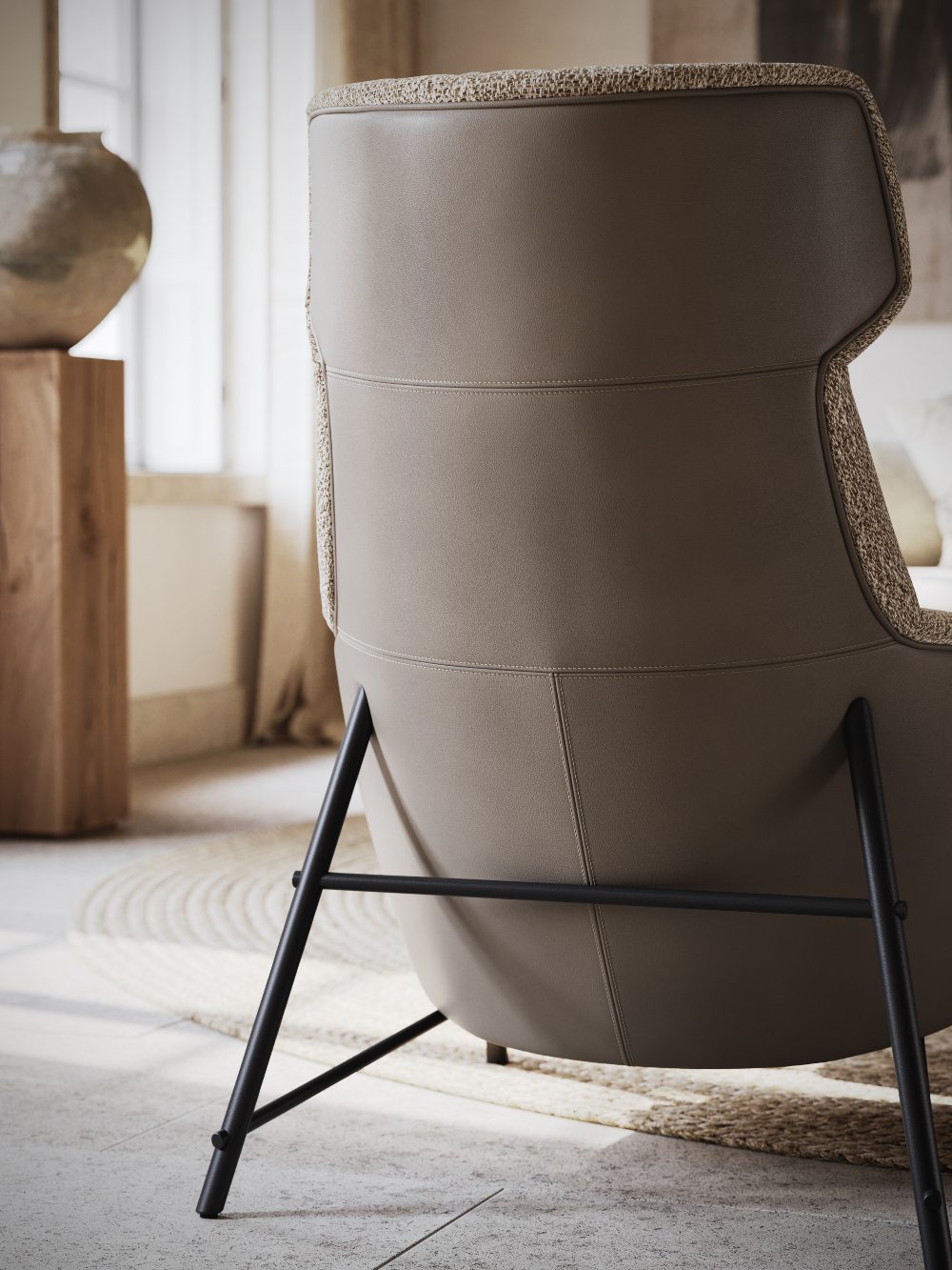 Custom Upholstery - Hubert Armchair back Back of an armchair upholstered in brown leather and with black steel legs.