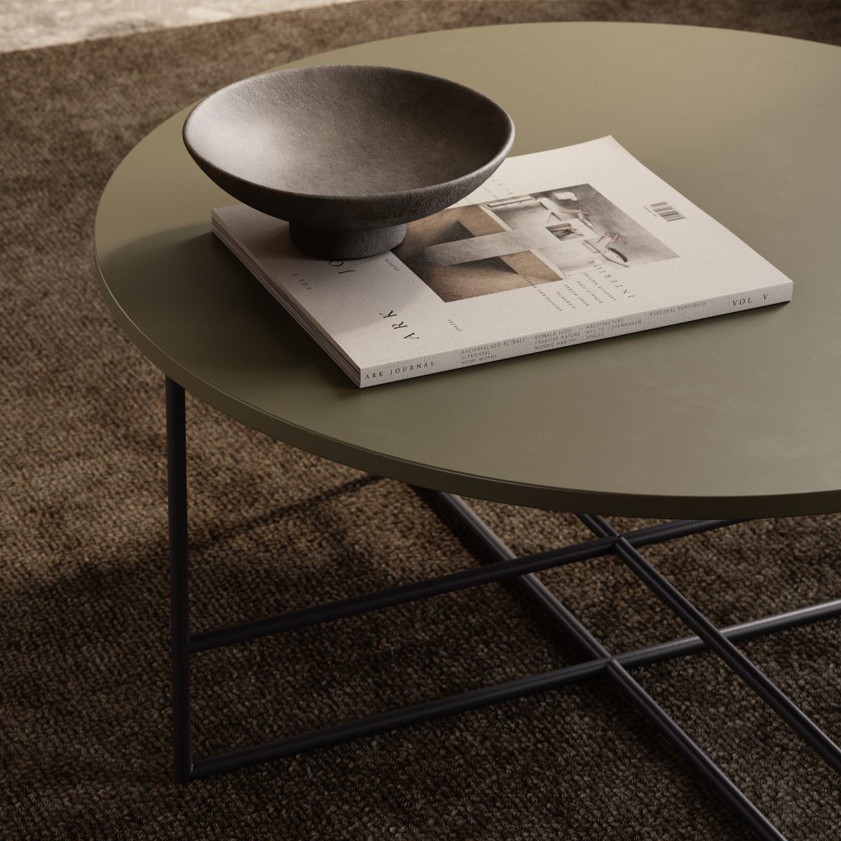 Inside Coffee Table Green A modern living room with a brown sectional sofa, a round coffee table, and a tall arc floor lamp. A large circular wall art piece and a sculpted bust on a pedestal decorate the space. Natural light streams through a tall window.