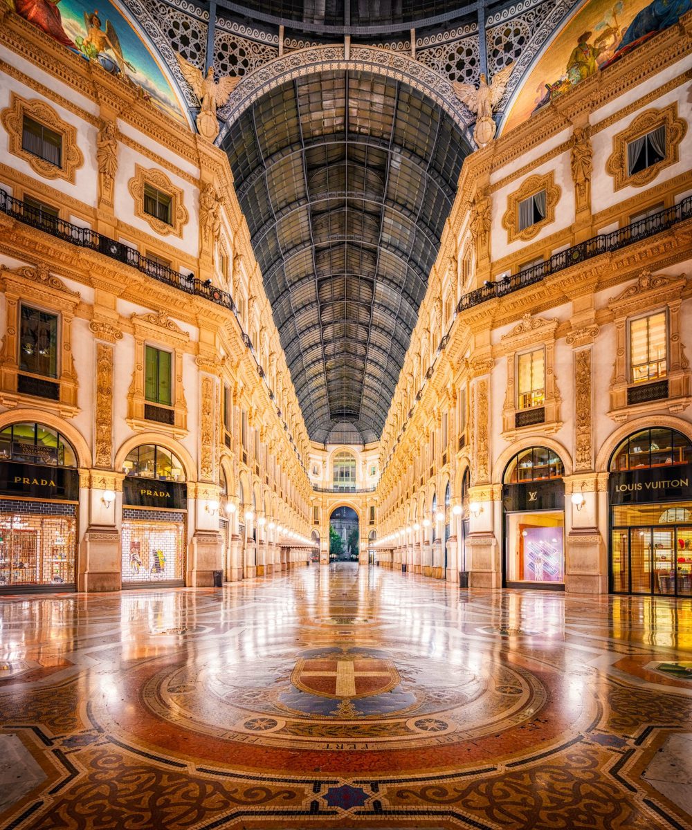 Milano-Shopping-Mall-Gallery-Vittorio-Emanuel (1) The interior of Galleria Vittorio Emanuelle II with people, creating a lively and dynamic atmosphere.