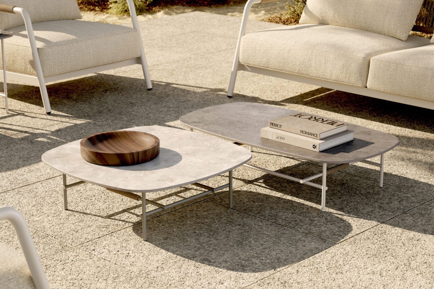 A spacious concrete patio equipped with two coffee tables and chairs, ideal for enjoying meals or socialising outdoors. Outdoor style by domkapa.