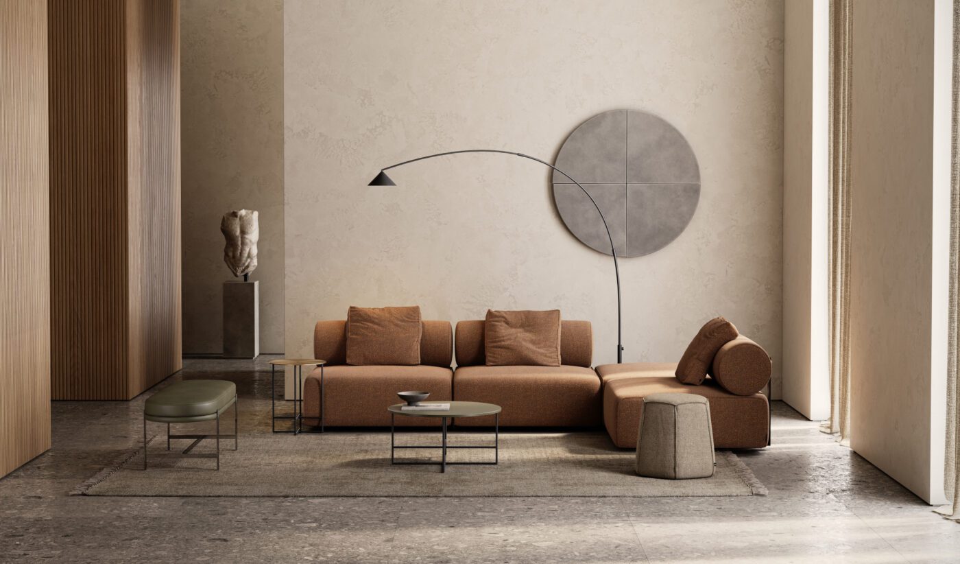 Shinto Sofa and Colbert Bench winter A modern living room with a terracotta sectional sofa, a round coffee table, and a tall arc floor lamp. A large circular wall art piece and a sculpted bust on a pedestal decorate the space. Natural light streams through a tall window. Perfect for winter. Interior Design Trends For Winter