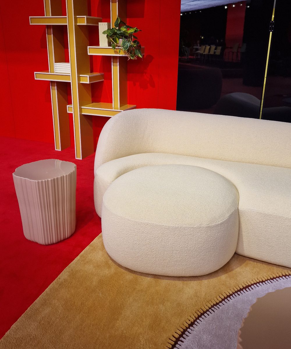 Sofa upholsted in white fabric and with organic shape. Captured at Salone del mobile 2025.