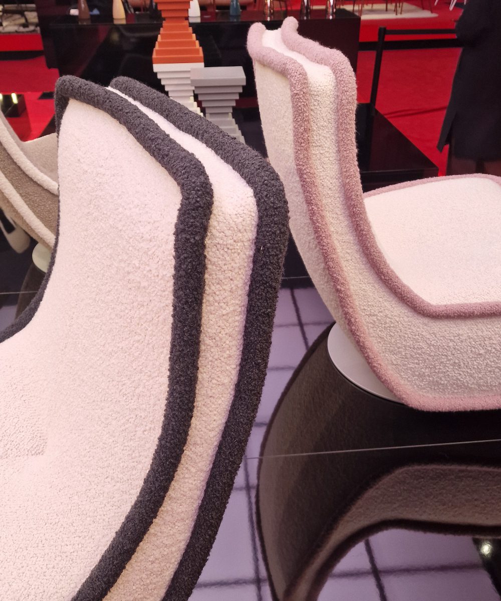 Armchairs captured at the Kartell stand at Salone del mobile 2025. Upholstered in a textured fabric in white and black or white and pink.
