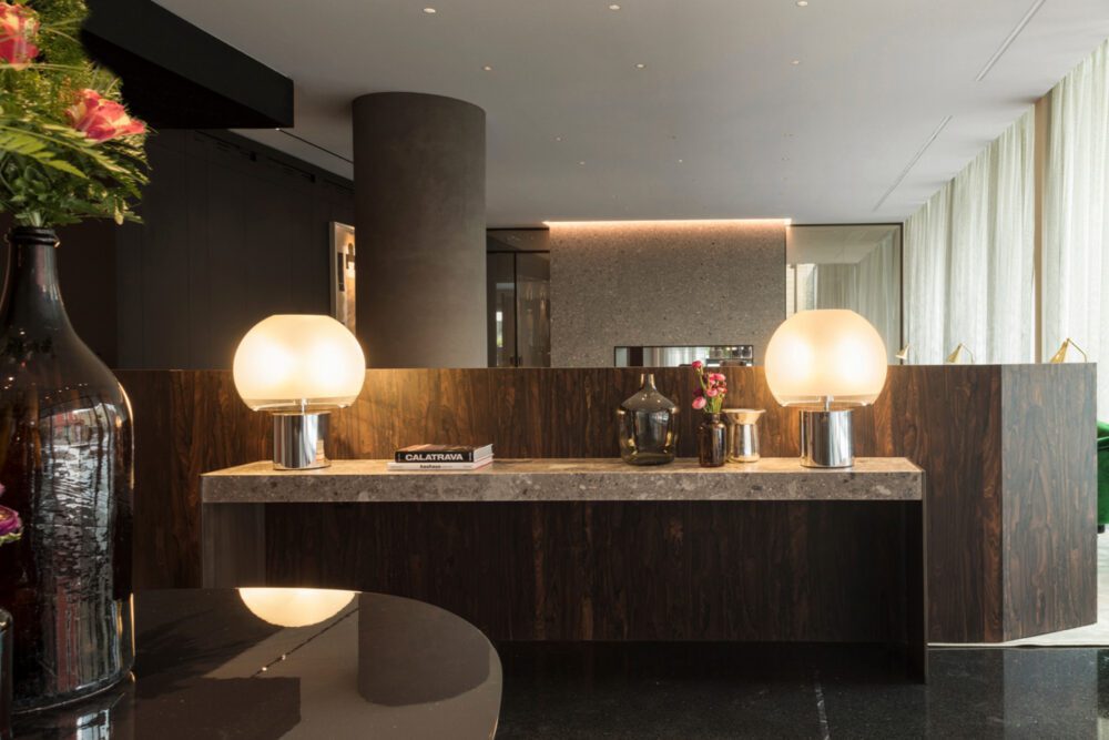VIU Milan 1 A sleek reception area featuring a large vase filled with colourful flowers, creating a welcoming atmosphere. At the Domkapa's travel guide to Milan.