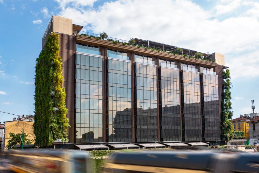 VIU Milan 2 (1) A contemporary structure topped with a lush green roof, showcasing eco-friendly design. VIU Milan Hotel.
