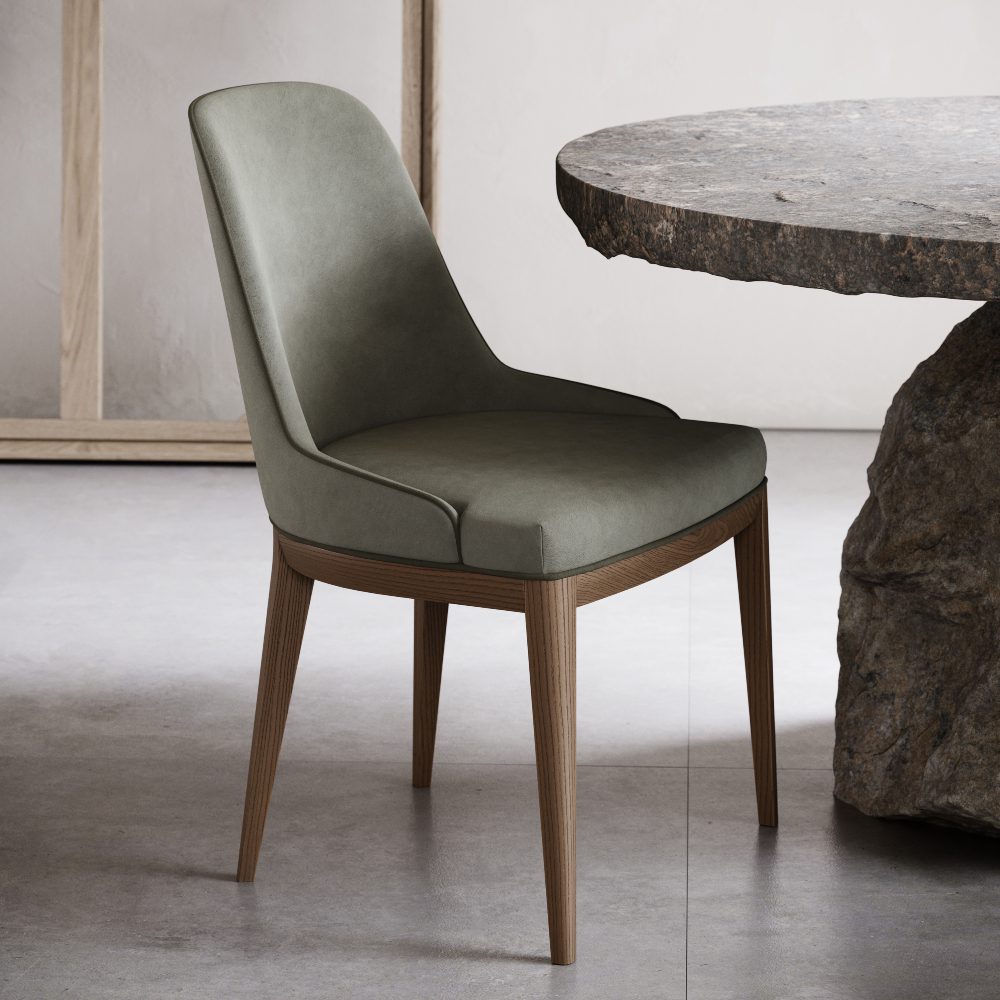 A green upholstered chair is positioned beside a stone table in a cosy home office setting.