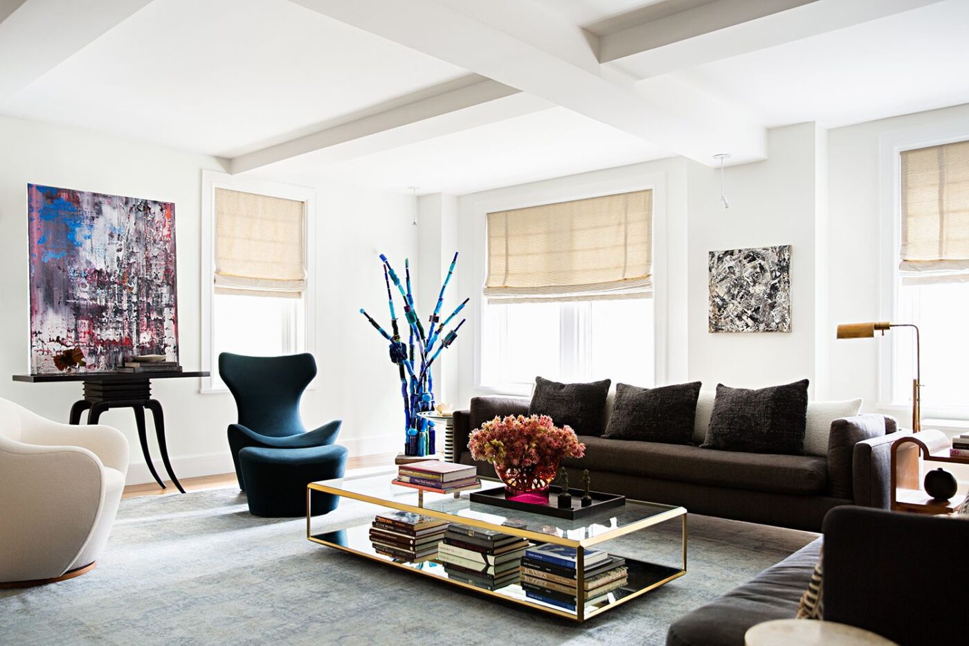 Danielle Colding Design Living room design by Danielle Colding Design. With a sofa with brown tones and a blue armchair. The coffee table is in glass and gold accents.