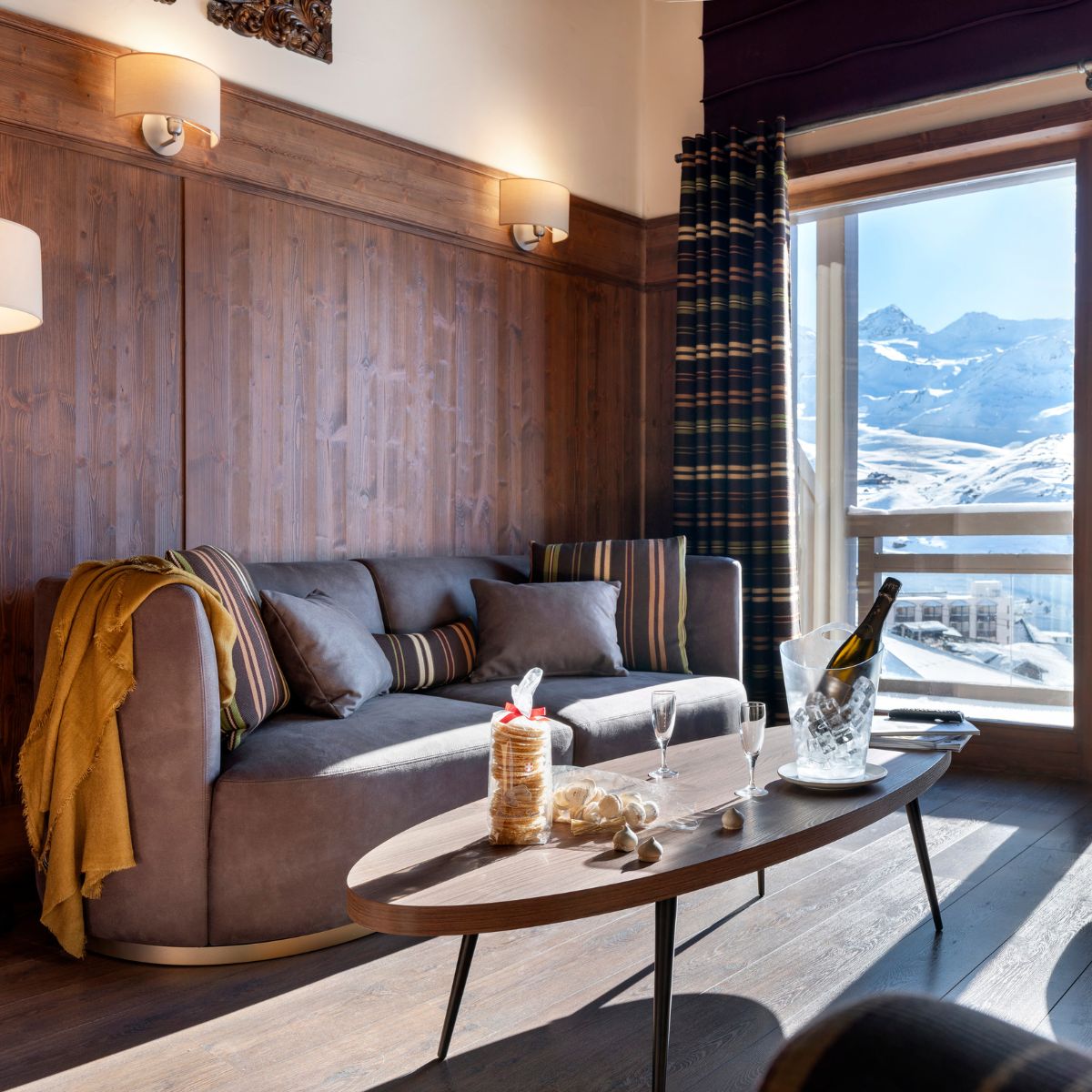 A cosy living room featuring a Domkapa sofa and coffee table, with a scenic view of mountains through the window.