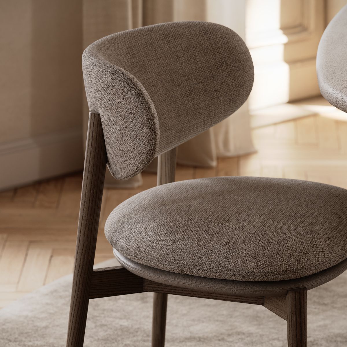 blog article about upholstery finishes by domkapa (10) A wooden table accompanied by a chair featuring a round seat, emphasising a cosy dining setup.