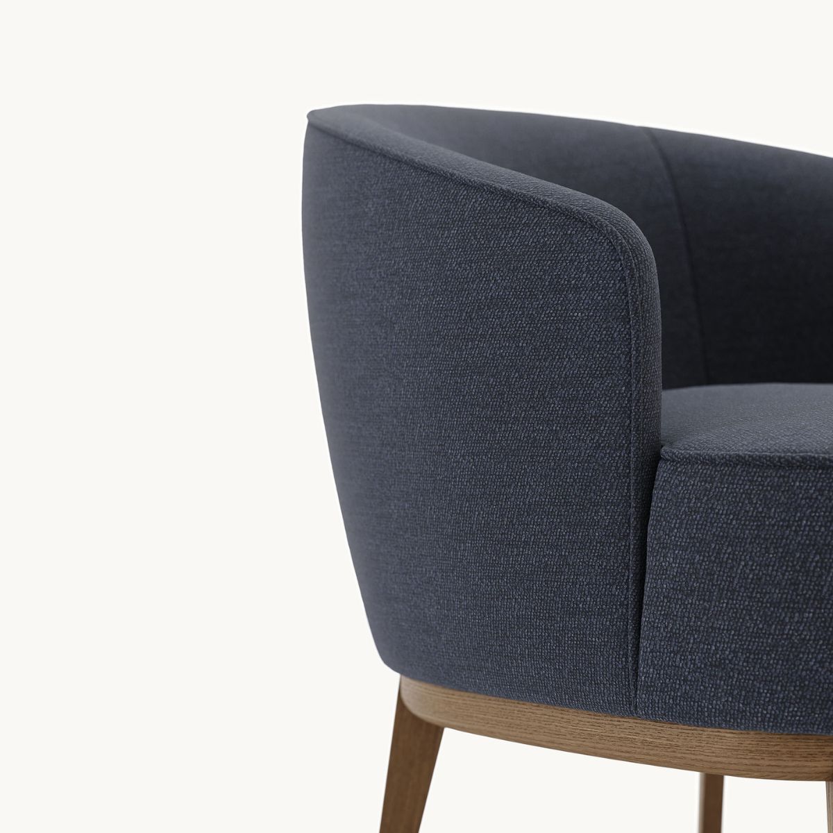 blog article about upholstery finishes by domkapa (2) A contemporary armchair with a dark blue upholstered seat, highlighting its elegant design, piping and modern appeal.