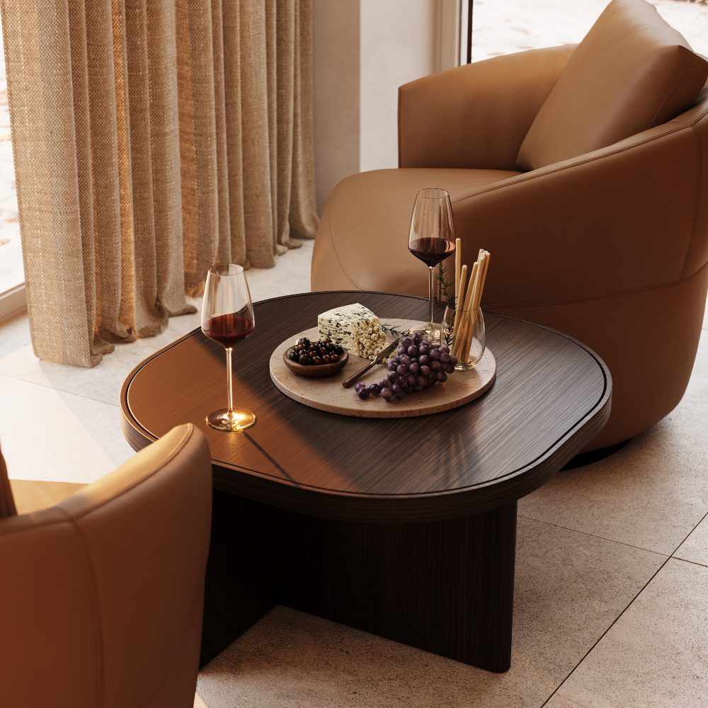 coffee table with snacks at a lounge A coffee table displaying an array of wine and cheese, inviting for a social gathering or tasting event.