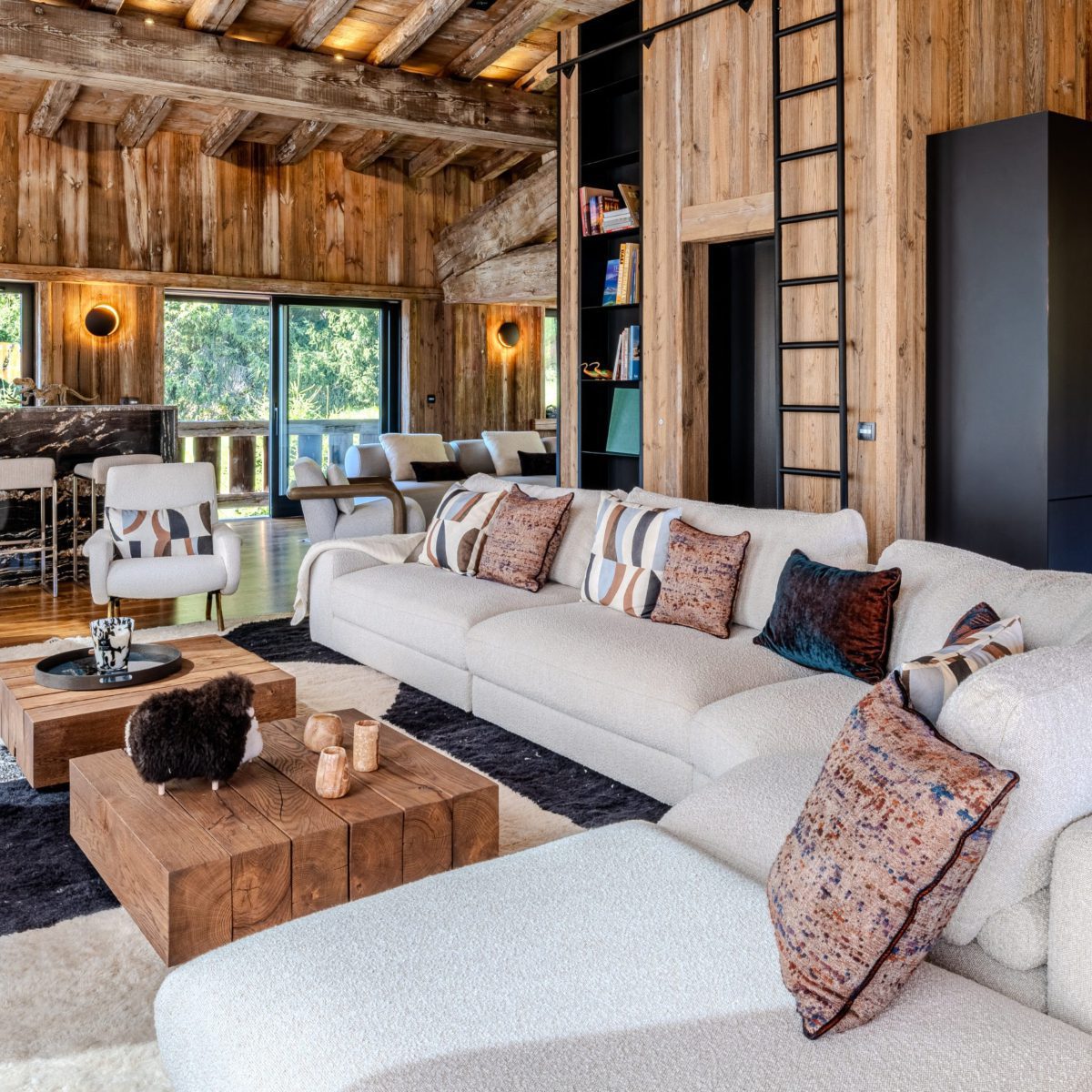 edward modular sofa at aloona project chalet infinity A spacious living room with a large modular sofa, enhancing the room's comfort and warmth. By Aloona Design.