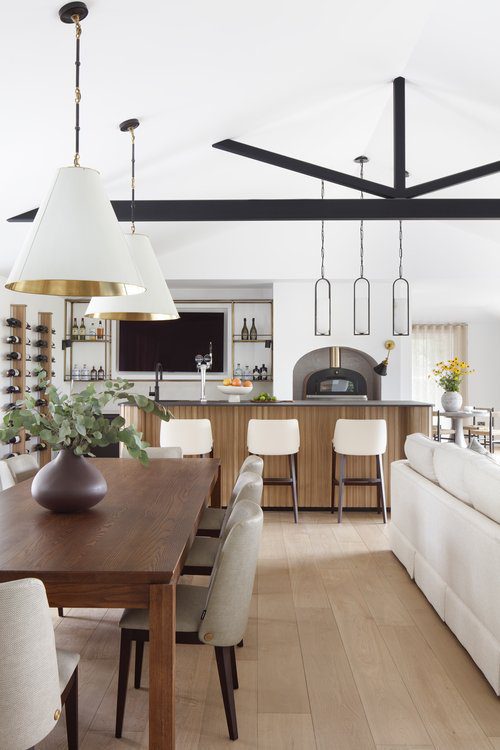Louise chair in Quirc Interior Design Project An elegant space with a dining table and chairs, designed for comfort and dining experiences. With a bar with white bar chairs, matching the grey chairs. By Quirc Interior Design.