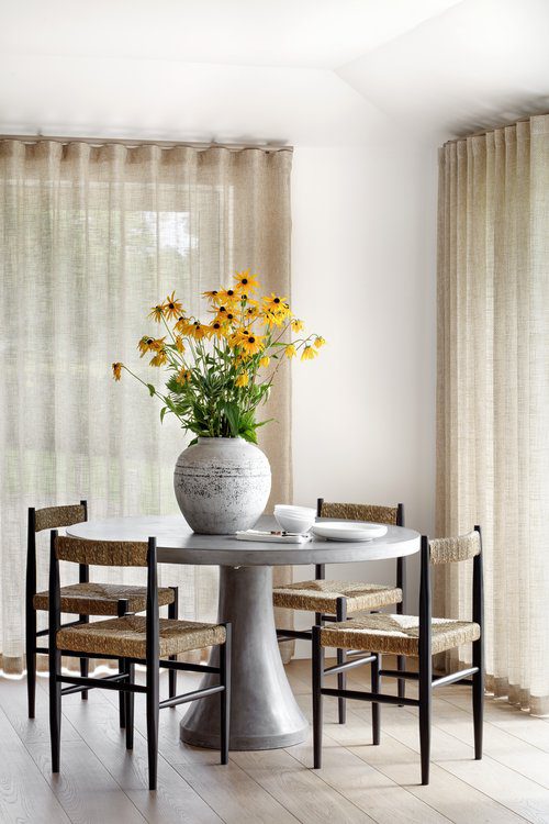 Dining room by Quic interior design An inviting dining room with a central table and comfortable chairs, designed for dining and socialising. By Quirc Interior Design.