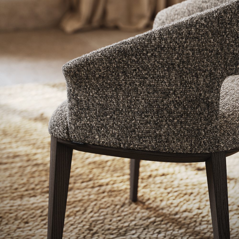 Close-up of a chair featuring a dark wood frame, highlighting its elegant design and craftsmanship.