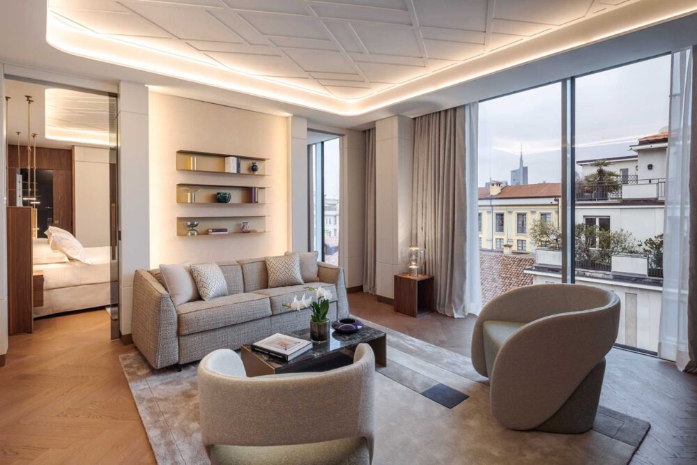 leonardo_suite_casa_baglioni_milan The living room of a hotel suite showcasing a stunning city skyline through expansive windows, with stylish decor. On Domkapa's Travel guide to Milan.