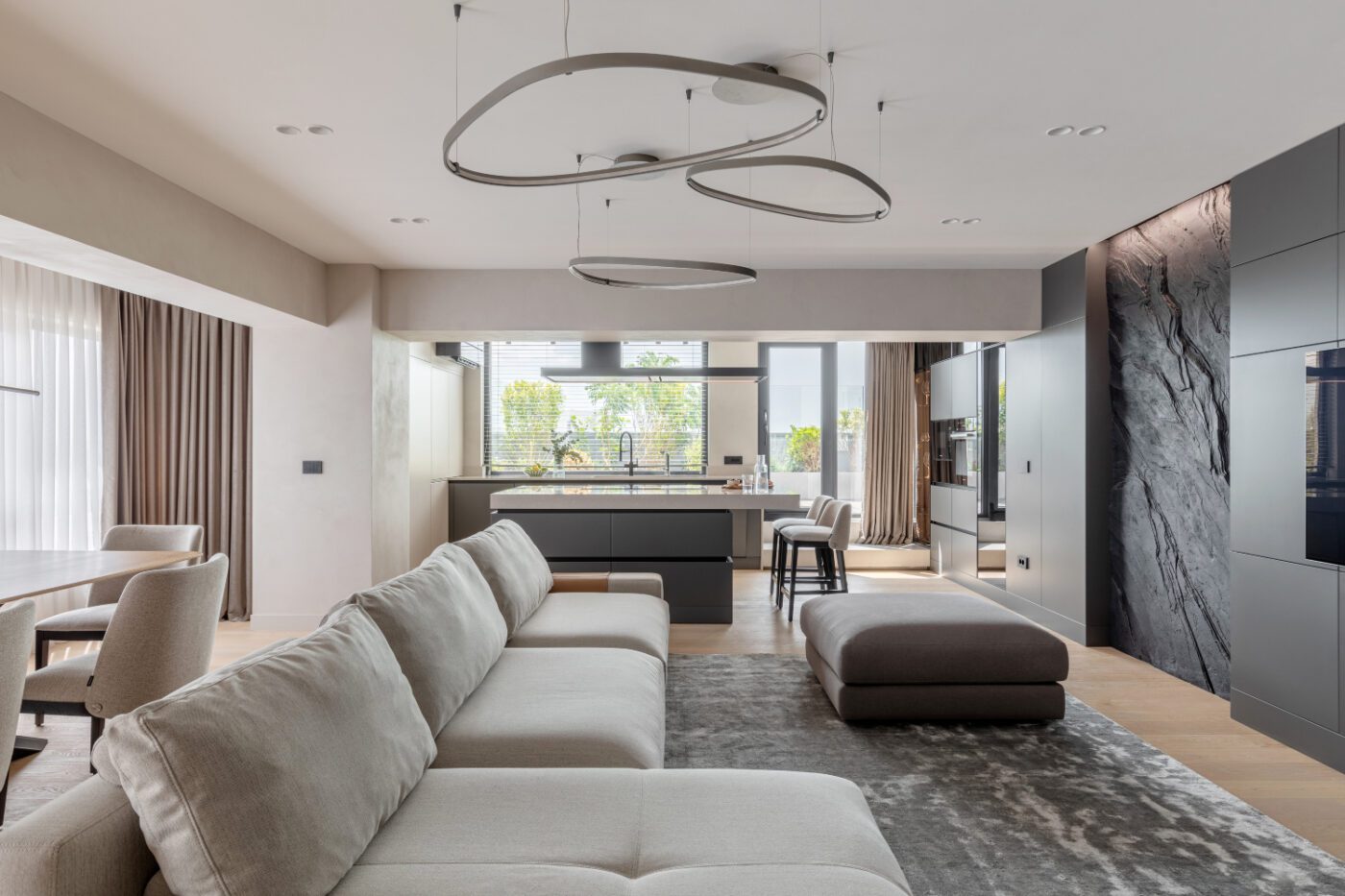 living room project by apunct studio A modern living room featuring a stylish modular sofa and a sleek kitchen, creating a cosy and inviting atmosphere.