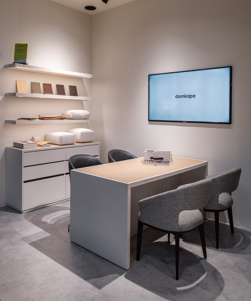 materials by domkapa at salone A spacious white office showcasing a desk and chairs, ideal for work or meetings. With a sample box and materials samples.