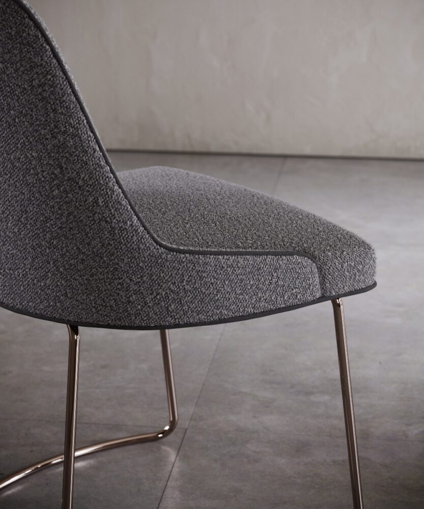 metal base anna chair A chair featuring a grey upholstered seat supported by a sleek metal frame.