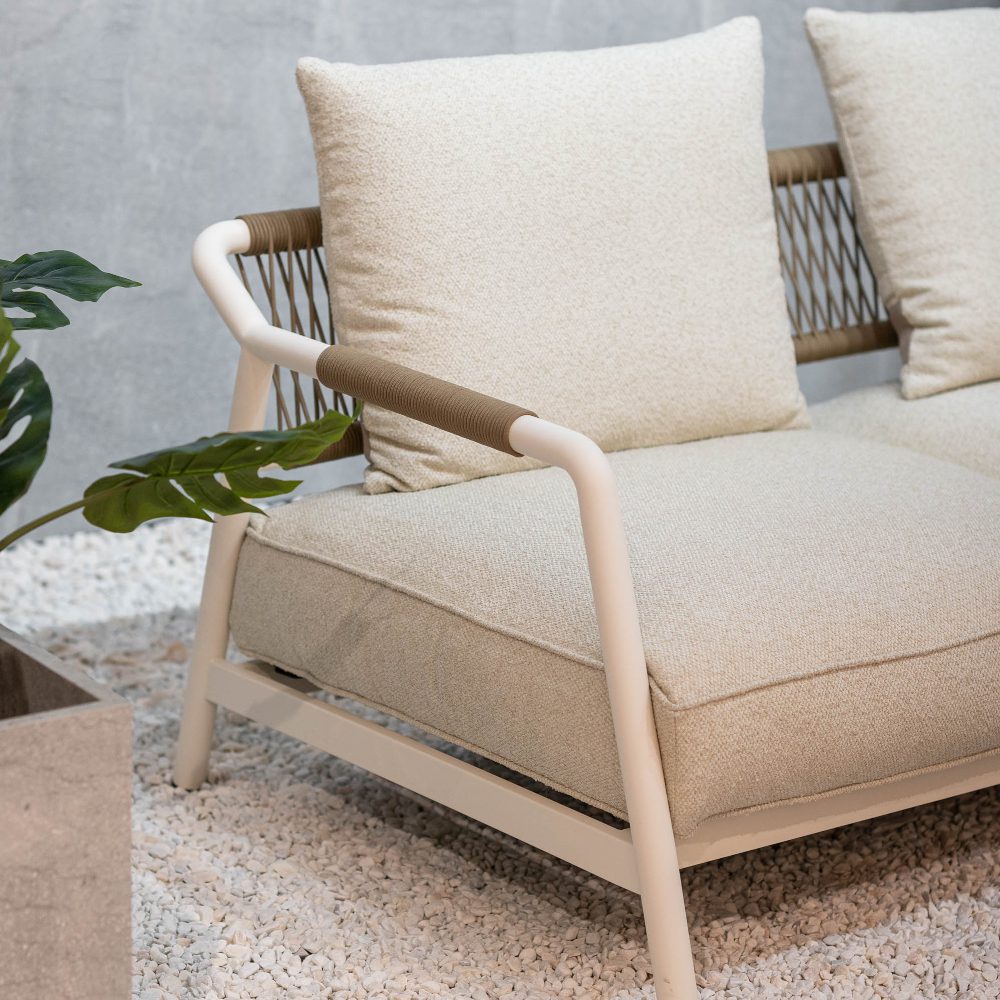Neroli, an outdoor sofa, captured at salone del mobile 2025. In white fabric with handcrafted details on the back and armrests.