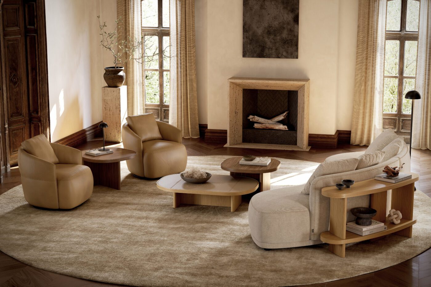 olivia sofa and alice armchairs, curved lines A modern living room showcasing a fireplace and a round rug, enhancing the space's warmth and charm. With a curved modular sofa and leather armchairs. Highlighing curved lines.