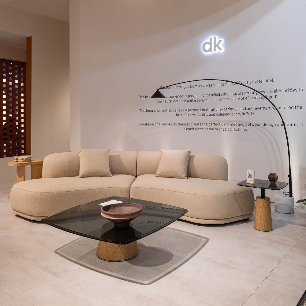 A welcoming living room at salone del mobile 2025 with a soft modular sofa, a chic coffee table, and a lamp adding warmth to the atmosphere.