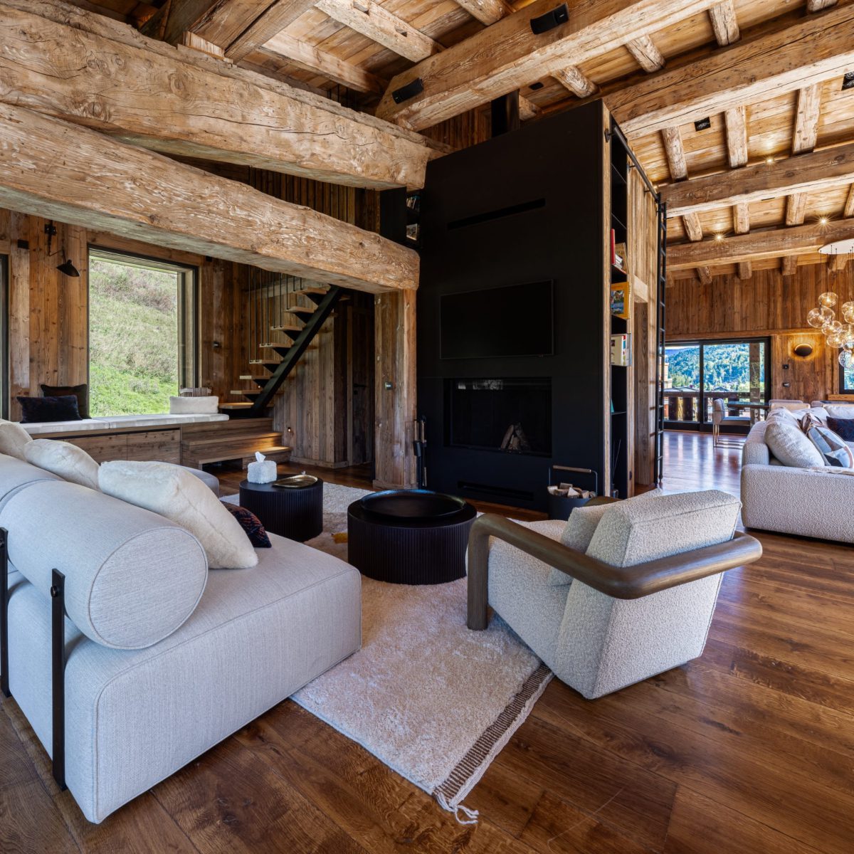 open space infinity challet aloona design A spacious living room showcasing a wooden ceiling and a comfortable white sofa, enhancing the room's elegance.