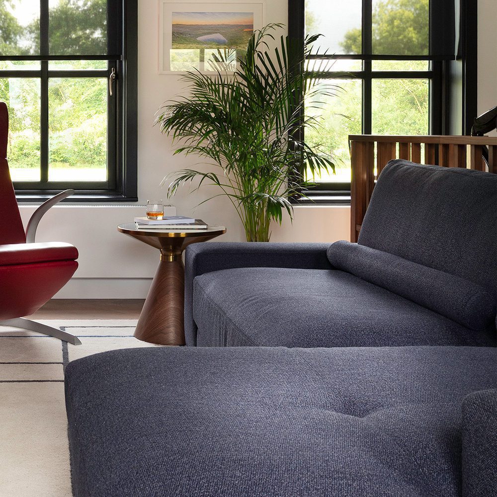 project by edit design studio with edward A living room setup with a comfortable couch, a chair, and a table, creating a welcoming atmosphere. by Edit Design Studio.