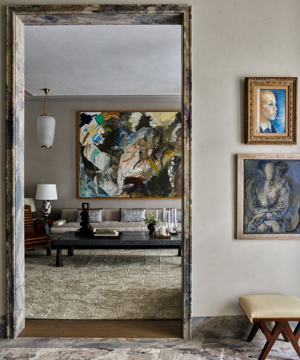 project_gambrel_dallas A well-decorated living room showcasing artwork on the walls and a sofa, contributing to a warm ambiance. By S.R. Gambrel